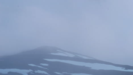 clouds flowing above snowy mountain in sweden, time lapse view