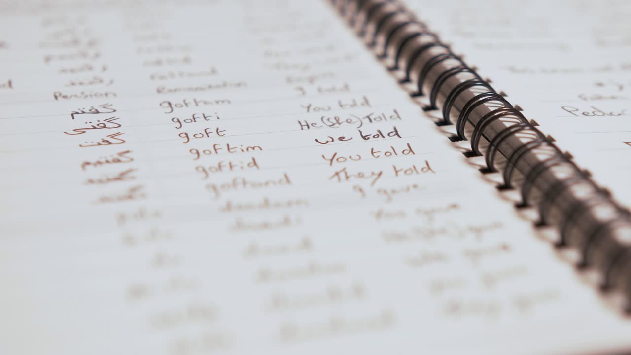 Learning Persian written verbs in organised notebook