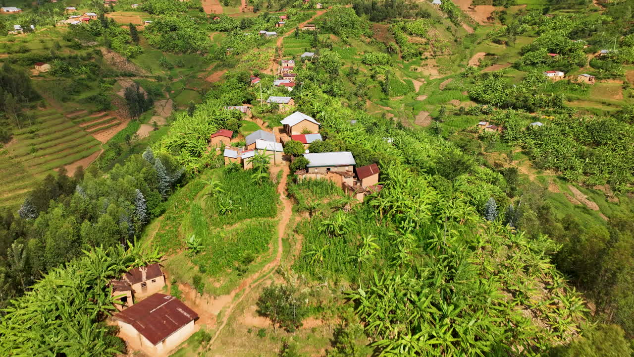 르완다의 산등성이에 있는 시골집 위를 드론이 날고 있다