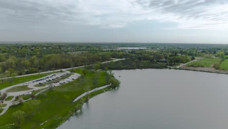 Langsame-Horizontale-Bewegung-Der-Drohne-über-Den-Horizont-Eines-Kleinen-Sees-Im-öffentlichen-Vorstadtpark