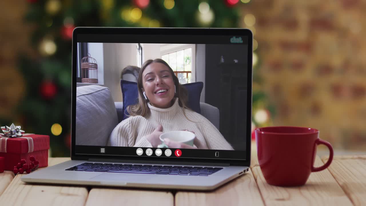 mujer caucásica feliz en videollamada en computadora portátil, con decoraciones de navidad y árbol