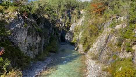 canyon rochoso com rio karwendelbach perto de scharnitz na áustria com árvores e altas montanhas karwendel ao fundo