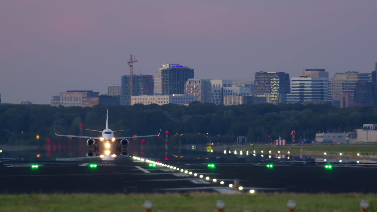 도시 위에서 저녁에 착륙하는 비행기