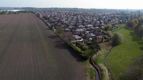 Countryside-housing-estate-aerial-view-flying-above-northern-England-farmland-residential-community-homes