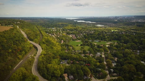 cinematic aerial shot of beautiful homes in a forested valley