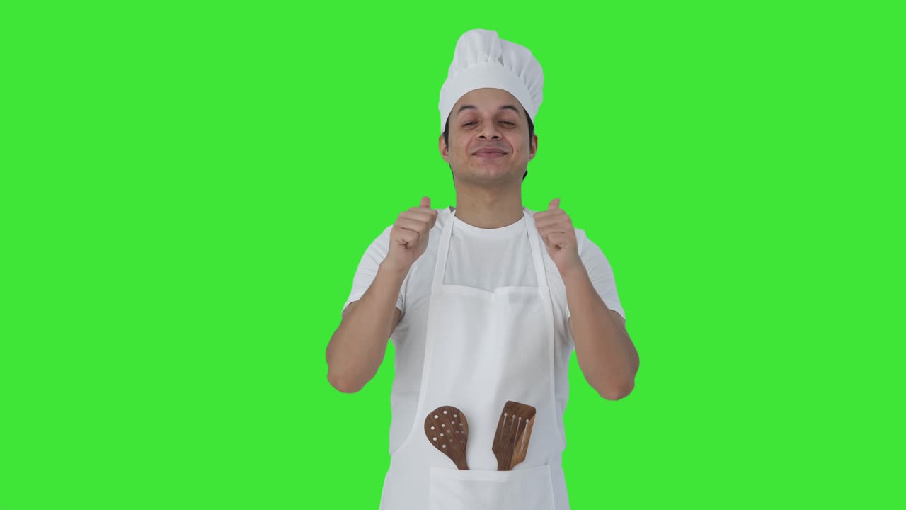 Felice chef professionista indiano che fa il pollice in su, schermo verde
