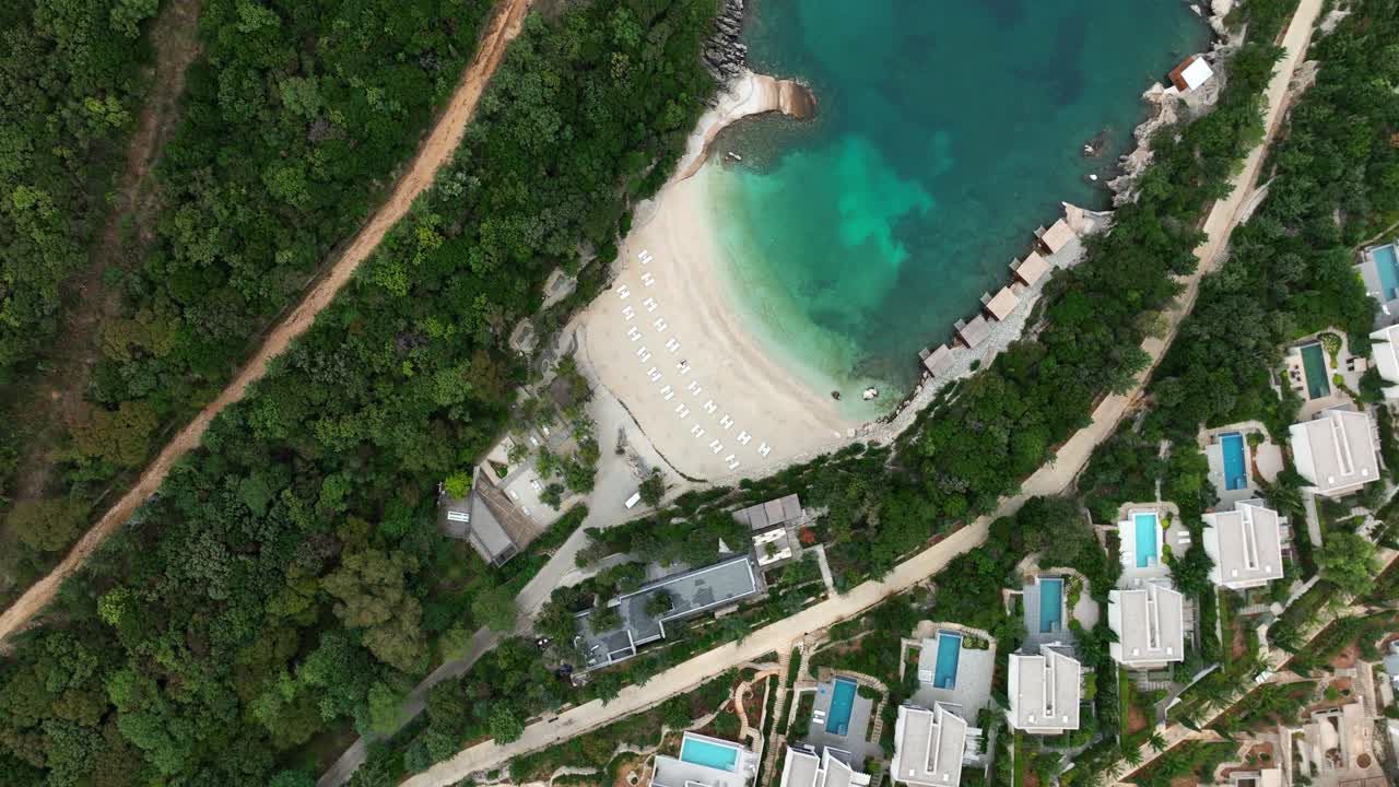 Saranda, Vlorë, Albania - A Secluded Turquoise Beach, Framed by Forest and Luxury Villas With Private Pools - Aerial Topdown Shot