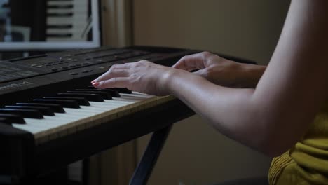 ultra alta definición, cámara lenta, cerca de una mujer asiática practicando en un teclado