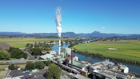 Rauch-Wabert-Aus-Der-Condong-Zuckerfabrik-Am-Ufer-Des-Tweed-River,-In-Der-Ferne-Ist-Eine-Bergwarnung-Zu-Sehen