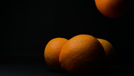 mano de mujer recoger fruta naranja, fondo negro