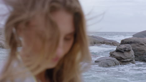 retrato de cerca de una mujer hermosa sonriendo disfrutando de la playa relajándose en la orilla del mar el viento soplando el cabello explorando un estilo de vida tranquilo y despreocupado