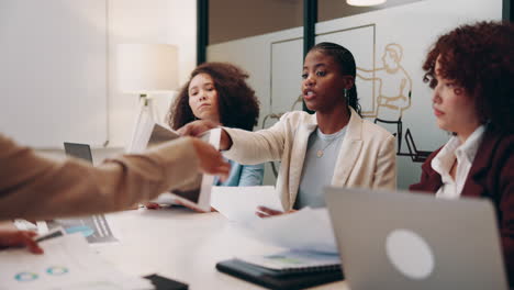 three businesswomen have a meeting in an office