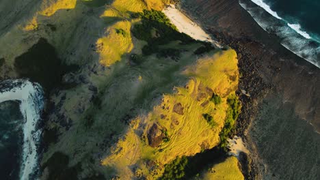 fotografía aérea sobre la isla de lombok con las famosas colinas de bukit merese y playas de arena con olas que se estrellan desde el océano. lombok, indonesia.