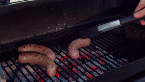 poner salchichas en la parrilla para cocinarlas en la barbacoa
