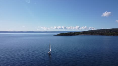 Drohnenaufnahme-Eines-Segelboots-Auf-Dem-Offenen-Ozean-In-Kroatien-Mit-Inselwolken-Und-Tiefblauem-Meer,-Während-Sich-Die-Kamera-Nähert