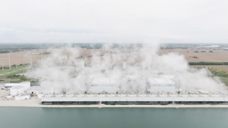 natural gas power plant by a cooling pond in rural countryside, aerial