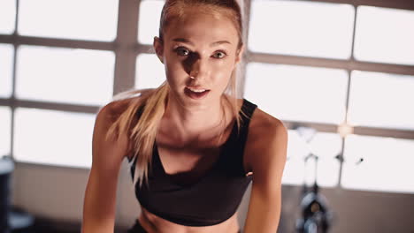 Determined-Young-Woman-Cycling-On-Stationary-Bike-At-Fitness-Studio-5