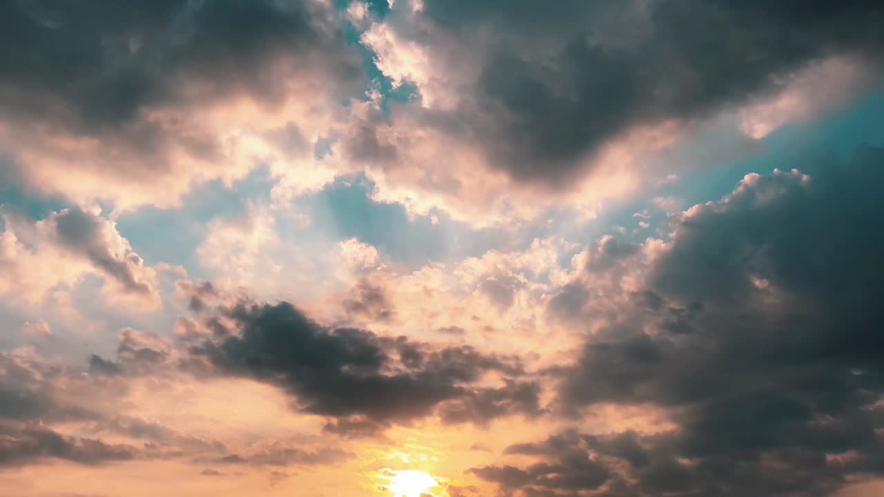 Cinematic low angle shot of a sunset sky with sunbeams breaking through clouds. Ideal for weather reports, travel vlogs, spiritual content, and environmental documentaries