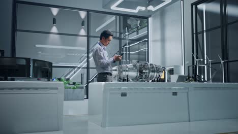 engineer reviewing a model engine in a modern research facility