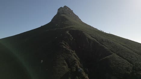 drone shot looking up at lion's head mountain looming high on the horizon.