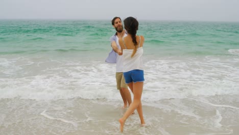 pareja caucásica divirtiéndose juntos en la playa 4k