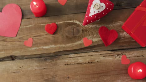 paper hearts and candles on wooden background at valentine's day