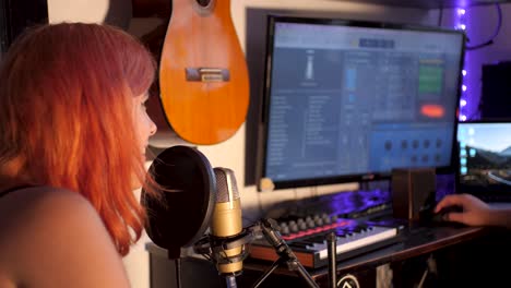 Mujer-Joven-De-Pelo-Naranja-Cantando-En-Un-Micrófono-Profesional-Para-Producir-Música-En-Un-Estudio-De-Producción-De-Música-En-Casa-|-Zoom-En-Cámara-Lenta-En-Imágenes-Del-Estudio-De-Producción-De-Música-Casera