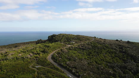 aerial drone tilt up shot over a beautiful hilltop viewpoint with the view of bluff beach and sea in the background in north island, new zealand