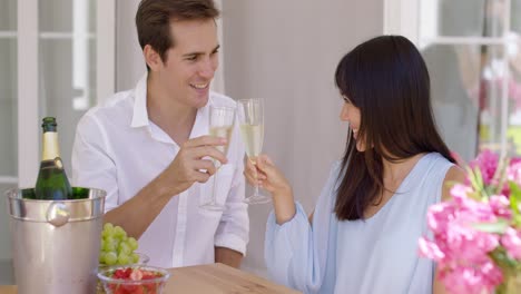 Young-happy-adult-couple-toasting-champagne