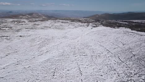 Luftaufnahmen-Der-Verschneiten-Landschaft-In-Lesotho,-Afrika---Schneefall-In-Afrika-Autofahren-Auf-Straßen-In-Verschneiter-Landschaft