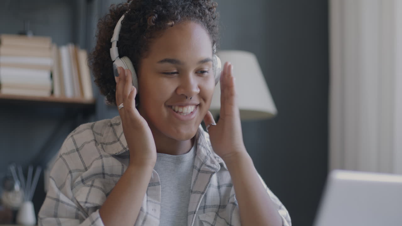 Teenage girl enjoying music and studying online