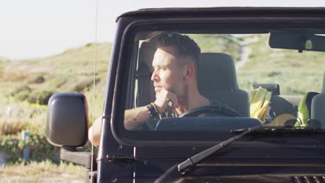 Hombre-Caucásico-Pensativo-Sentado-En-El-Coche-Mirando-Hacia-Otro-Lado-En-Un-Día-Soleado-En-La-Playa