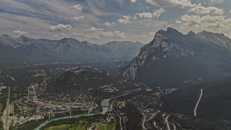 Banff-AB-Canada-Aerial-v43-high-panning-view-capturing-spectacular-national-park-landscape-featuring-Rundle-and-Cascade-mountain-ranges,-forest-valley-and-town---Shot-with-Mavic-3-Pro-Cine---July-2023