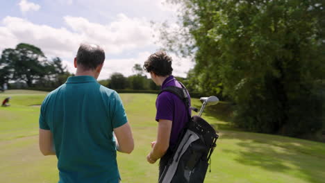 male golf players wearing uniforms, talking and holding golf ball and clubs on golf course