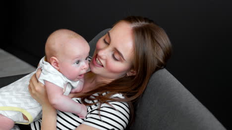 mom and baby chat sitting on sofa on dark background