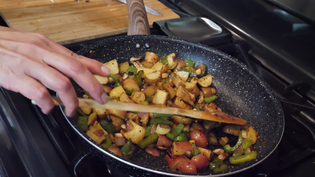 cocinar verduras mixtas y patatas fritas en sartén en casa, cámara lenta