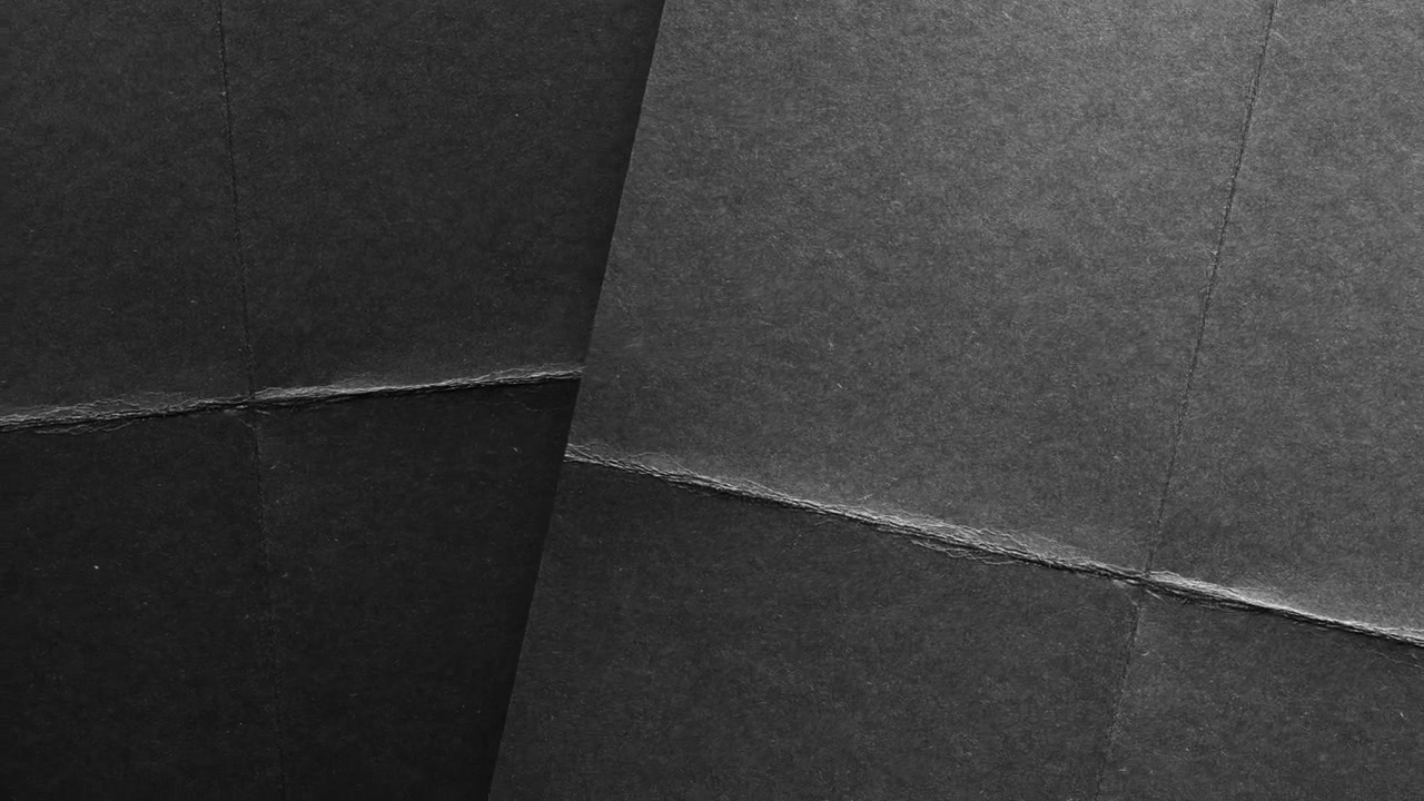 Abstrakt sort og grå papirtekstur med folder og diagonal opdeling