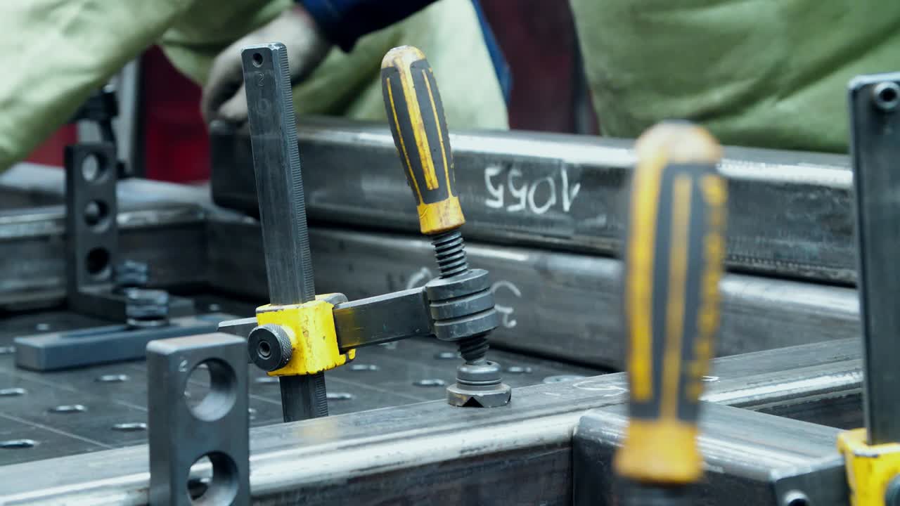 los trabajadores instalan gran billeta de metal para el procesamiento en el taller de trabajo