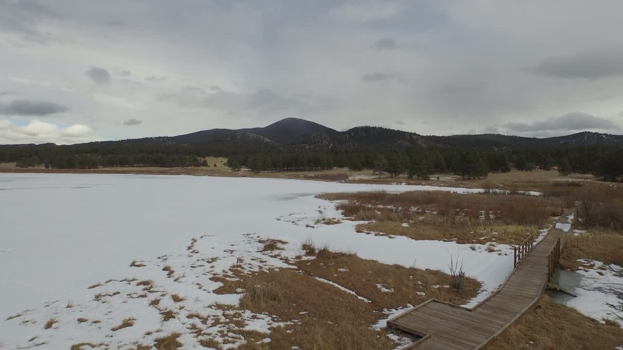 Veduta aerea con drone delle pianure innevate del Colorado con montagne sullo sfondo.