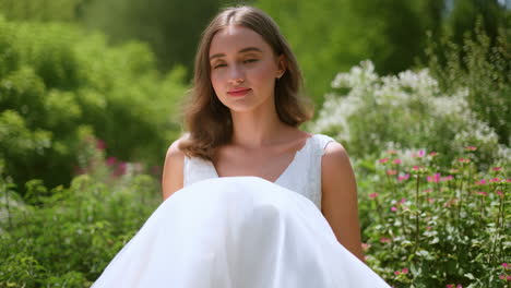 Young woman in a white dress in a lush garden
