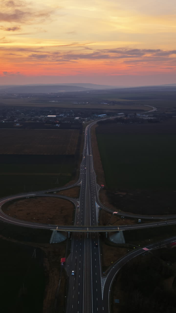 Aerial drone view of cars driving on the highway in Moldova at sunset time lapse. Vertical