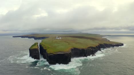 wide aerial dolly captures loop head lighthouse on the dramatic headland, surrounded by sea and cliffs