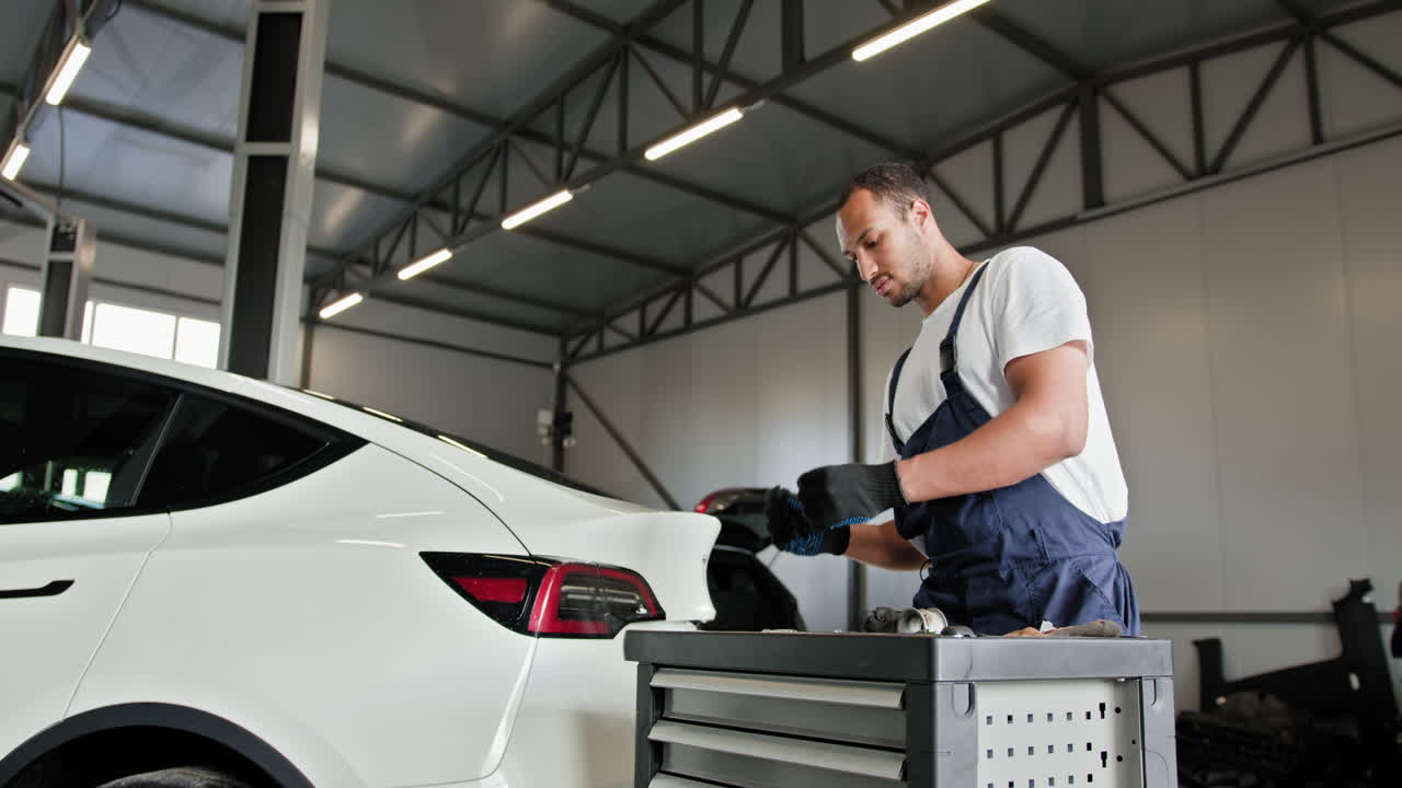 mecánico de automóviles trabajando en un tesla en un garaje