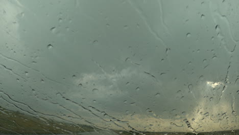 raindrops on car windscreen during severe summer storm rain