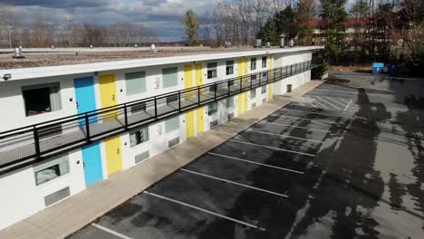blue and yellow hotel motel doors at deserted building, recently painted, aerial drone shot