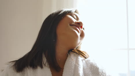 una mujer relajándose junto a la ventana.