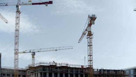 Grúas-Torre-En-El-Trabajo-En-Un-Sitio-De-Construcción-Durante-El-Día