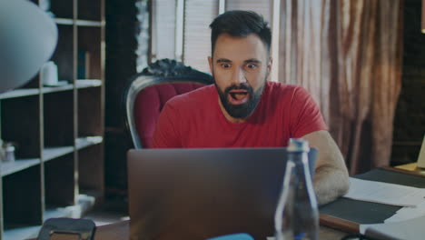 hombre de negocios feliz leyendo buenas noticias en una computadora portátil en la oficina. sí firma