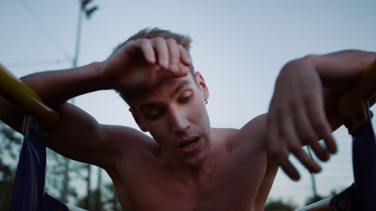 피곤한 스포츠맨이 운동 후 야외에서 휴식을 취하고 있습니다. 스포츠맨이 휴식을 취하고 있습니다.