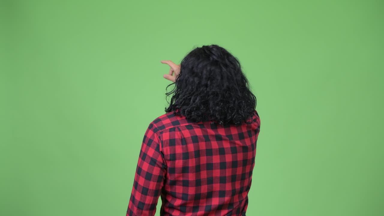 Vista posteriore di un uomo hipster che punta il dito